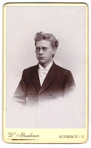 Fotografie W. Bruckner, Auerbach i / V., Portrait junger Herr im Anzug mit Fliege und Zwicker