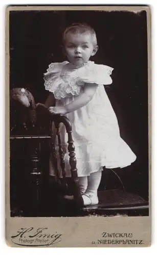 Fotografie H. Imig, Zwickau, Portrait kleines Mädchen im weissen Kleid auf Stuhl stehend