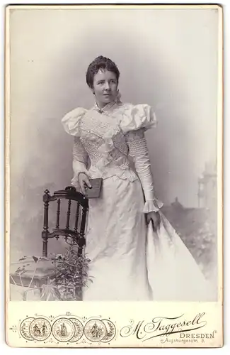 Fotografie M. Taggselle, Dresden, Dame im weissen reichlich verzierten Kleid mit Brosche