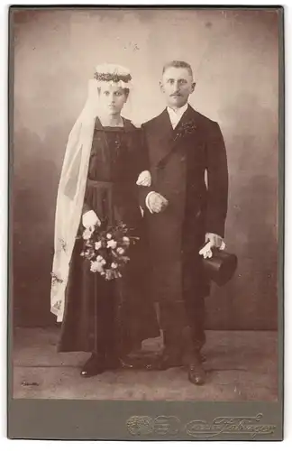 Fotografie Atelier Fabinger, Markneukirchen i. Sa., Eheleute im schwarzen Brautkleid und Anzug samt Zylinder