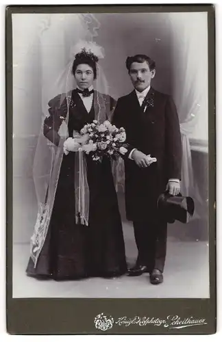 Fotografie Scheithauer, Zwickau i. Sa., junges Brautpaar im schwarzen Hochzeitskleid und Anzug, Zylinder