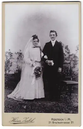 Fotografie Heinr. Zabel, Rostock i. M., Ehepaar am Hochzeitstag im Brautkleid und Anzug