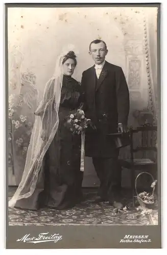 Fotografie Max Freitag, Meissen i. Sa., junge Eheleute um schwarzen Brautkleid und Anzug mit Zylinder