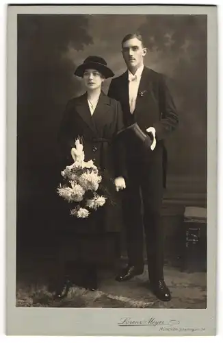 Fotografie Lorenz Meyer, München, bayrisches Ehepaar im schwarzen Mantel und im Frack mit Zylinder, 1921