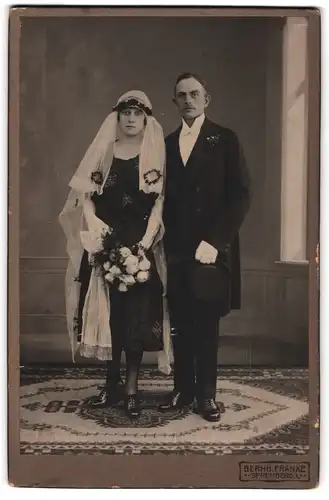 Fotografie Bernh. Franke, Spremberg, Hochzeitspaar im schwarzen Brautkleid nebst Mann im Anzug mit Zylinder