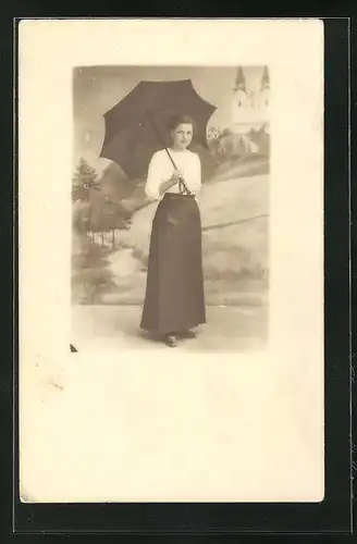Foto-AK Junge Dame in weisser Bluse mit Schirm vor einer Studiokulisse