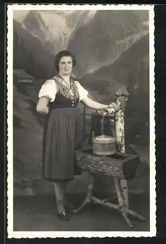 Foto-AK Frau in Tracht am Brunnen vor einer Studiokulisse