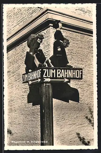 AK Bahn trägt Taschen einer Dame auf Wegweiser zum Bahnhof