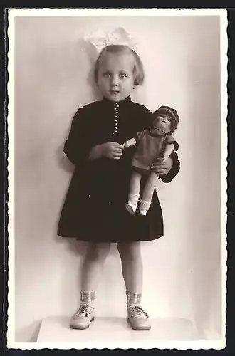 Foto-AK Junges Mädchen in schwarzem Kleid mit geschminkter Puppe