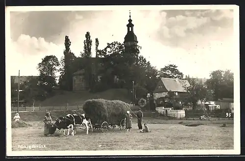 AK Königsbrück, Ortspartie mit Kirche und Bauern mit Ochsen-Heuwagen