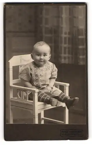 Fotografie Hans Wanderer, Klagenfurt, niedlicher Knabe Ernst Saukup im Kleid auf einem Stuhl sitzend