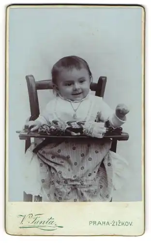 Fotografie Vaclav Fanta, Prag, Portrait kleines Kind Jirina Kahudova im Kindersitz mit Puppe, 1907