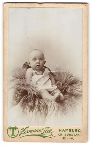 Fotografie Hermann Tietz, Hamburg, Portrait kleiner Junge Lenni Roblin auf einem Fell sitzend
