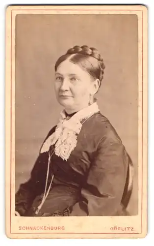 Fotografie Schnackenburg, Görlitz, Portrait Frau Adolphine im dunklen Kleid mit geflochtenen Haaren