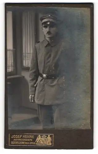 Fotografie Josef Henne, Düsseldorf, Soldat in Feldgrau Uniform mit Schirmmütze