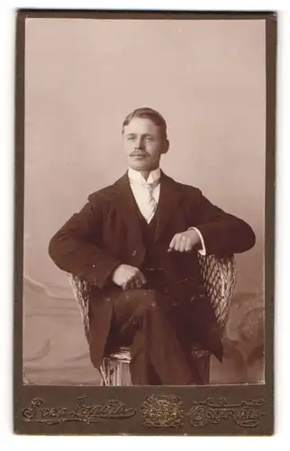 Fotografie Sven Lundin, Östervala, Portrait junger Herr eleganter Kleidung im Korbstuhl sitzend