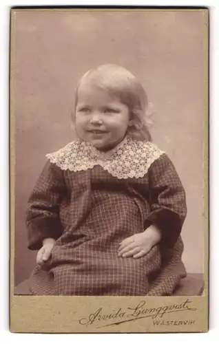 Fotografie Arvida Ljungqvist, Wästervik, Portrait kleines Mädchen im karierten Kleid mit Spitzenkragen