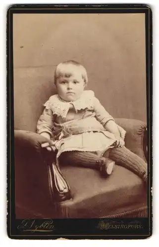 Fotografie D. Nyblin, Helsingfors, Portrait kleines Mädchen im hübschen Kleid auf Sessel sitzend