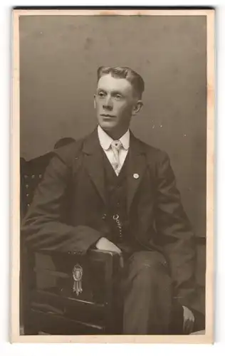 Fotografie Anna Hedström, Örebro, Portrait sitzender Herr im Anzug mit Krawatte
