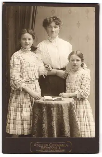 Fotografie Atelier Germania, Dresden-A, Portrait bürgerliche Dame mit zwei Mädchen und Buch am Tisch