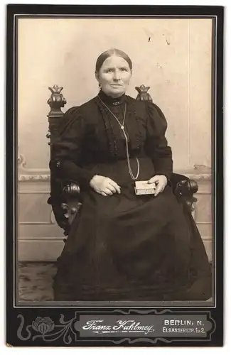 Fotografie Franz Kuhlmey, Berlin-N, Portrait ältere Dame im schwarzen Kleid mit Buch in der Hand