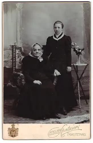 Fotografie Robert Spatzier, Trautenau, Portrait alte Frau mit Kopftuch auf Stuhl sitzend und junge Dame