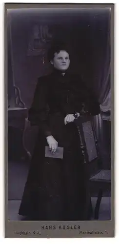 Fotografie Hans Kugler, Kirchhain N / L, Portrait junge Dame im schwarzen Kleid mit Buch an Stuhl gelehnt