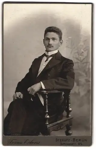 Fotografie Franz Erkens, Berlin-Steglitz, Portrait sitzender Herr in eleganter Kleidung mit Krawatte