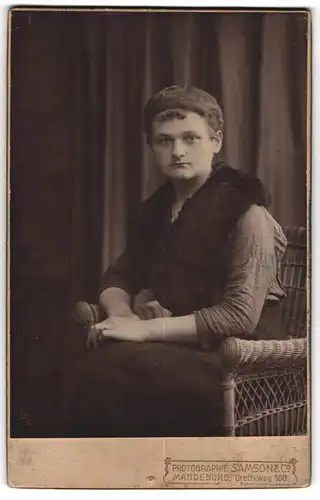 Fotografie Samson & Co., Magdeburg, Portrait modisch gekleidete Dame im Korbstuhl sitzend