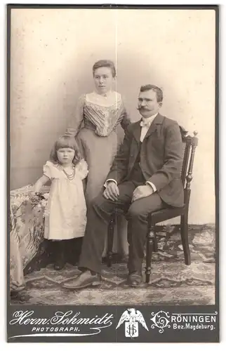 Fotografie Herm. Schmidt, Gröningen, Portrait bürgerliches Paar mit kleiner Tochter
