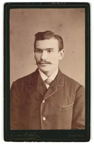 Fotografie A. zur Mühlen, Bremen, Portrait modisch gekleideter Herr mit Fliege und Zwirbelbart