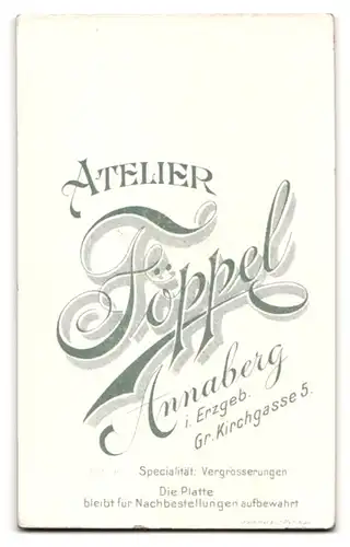 Fotografie H. Föppel, Annaberg i / Erzgeb., Portrait niedliches Kleinkind im weissen Kleid auf Tisch sitzend
