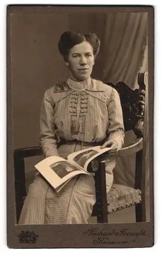 Fotografie Richard Freundt, Hannover, Portrait sitzende Dame im gestreiften Kleid mit Zeitung