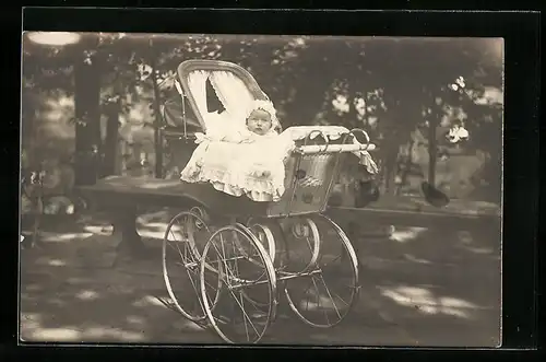 Foto-AK Kleinkind im Taufkleid, im Kinderwagen in einem Park