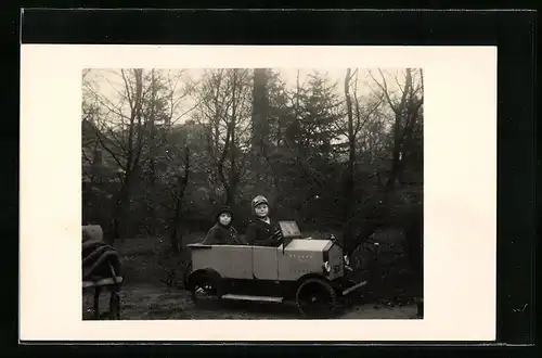 Foto-AK Zwei Kaben in einem Spielzeugauto im Freien