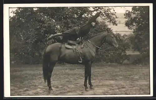 Foto-AK junger Mann beim voltigieren auf seinem Pferd