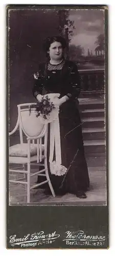Fotografie Emil Kunert, Berlin-Weissensee, Portrait Dame in langem Kleid mit Blumenstrauss