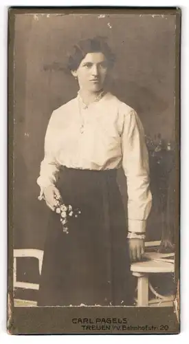 Fotografie Carl Pagels, Treuen i.V., Portrait junge Frau in weisser Bluse mit Blumenblüten in Händen