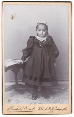 Fotografie Reinhold Ernst, Görlitz, Portrait kleines Mädchen im modischen Kleid mit Bilderbuch
