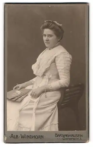 Fotografie Alb. Windhorn, Barsinghausen, Portrait bürgerliche Dame mit Fotos auf Hocker sitzend