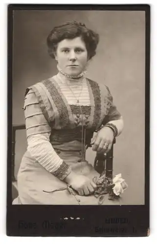 Fotografie Hans Meyer, Linden, Portrait sitzende Dame im hübschen Kleid mit Rose