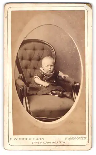 Fotografie F. Wunder Sohn, Hannover, Portrait niedliches Kleinkind im hübschen Kleid auf Sessel sitzend