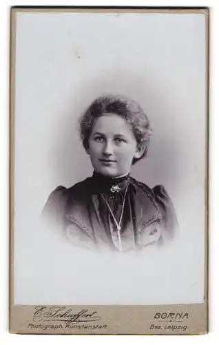 Fotografie Emil Schuffert, Borna i / S., Portrait junge Dame im schwarzen Kleid mit Kragenbrosche