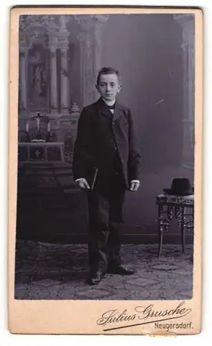 Fotografie Julius Grusche, Neugersdorf, Portrait halbwüchsiger Knabe im Anzug mit Fliege und Buch