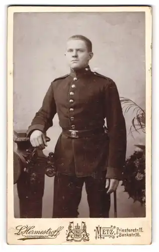 Fotografie L. Hermestroff, Metz, Portrait Soldat in Uniform an Sockel gelehnt