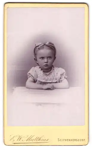 Fotografie W. W. Matthias, Seifhennersdorf, Portrait kleines Mädchen im hübschen Kleid mit Haarschleife