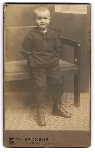 Fotografie Th. Backens, Marne i. Holstein, Portrait kleiner Junge im Matrosenanzug