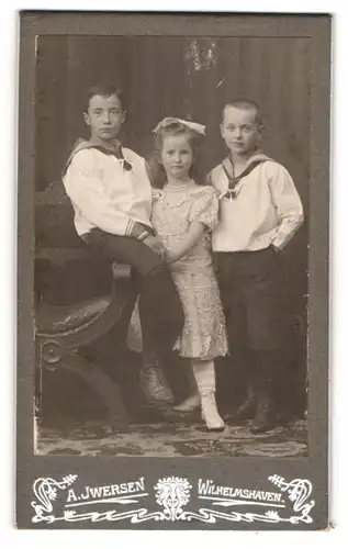 Fotografie A. Iwersen, Wilhelmshaven, Portrait zwei Jungen in Matrosenanzügen mit einem Mädchen