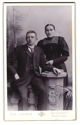 Fotografie Chr. Jessen, Delmenhorst, Portrait junges Paar in eleganter Kleidung an Sockel gelehnt