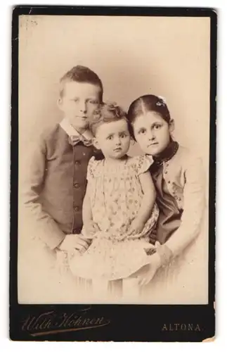 Fotografie Wilh. Köhnen, Hamburg-Altona, Portrait zwei kleine Mädchen und Junge in modischer Kleidung